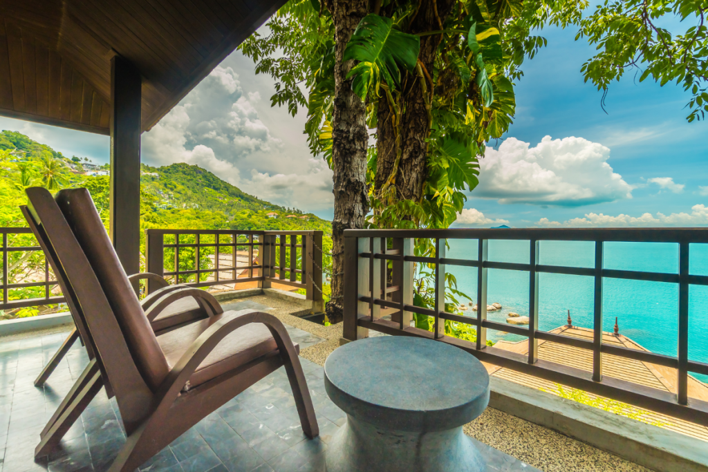 A balcony featuring two chairs with a view of the ocean, creating a serene and inviting outdoor space.