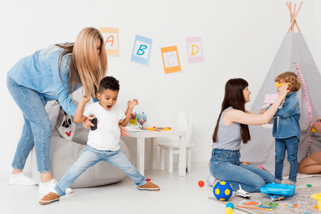 A woman and two children joyfully playing together in a colorful playroom filled with toys and games.
