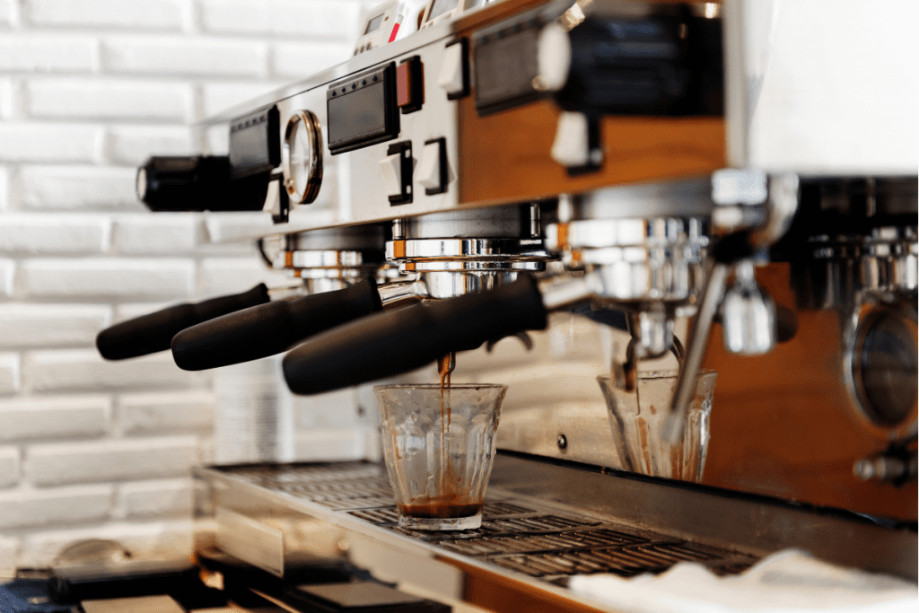 A coffee machine brewing a fresh cup of coffee, steam rising from the spout.