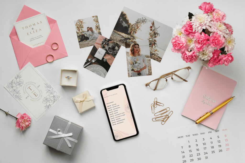 Elegant wedding stationery and gifts displayed on a wooden table, featuring invitations, place cards, and decorative items.